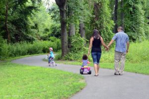 a family walking and biking on the Appomattox River Trail at Roslyn Landing Park in Colonial Heights