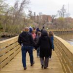A group of about ten people walking away from the camera on the Hopewell Riverwalk